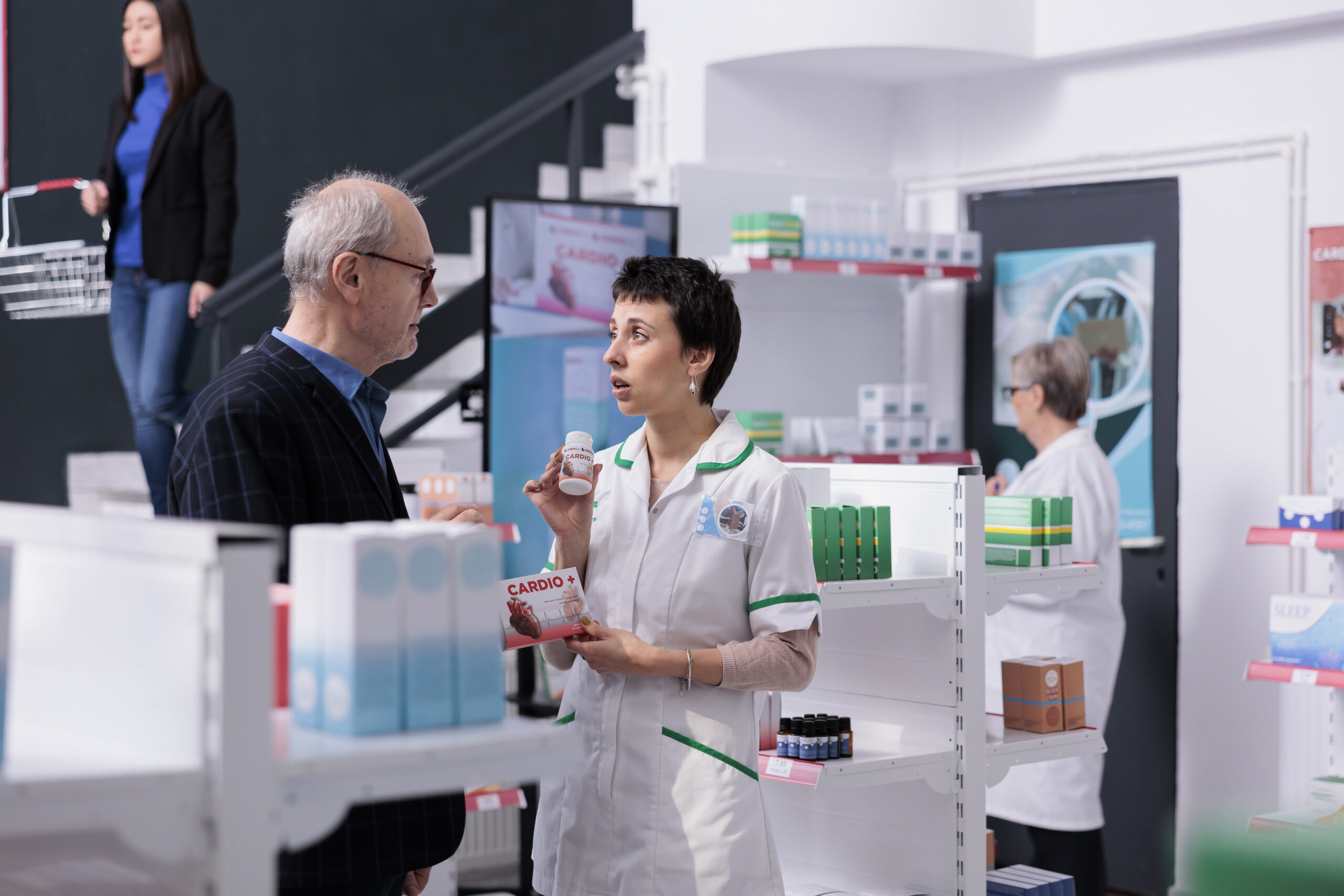 Medical employee showing customer heart pills and giving recommendations
