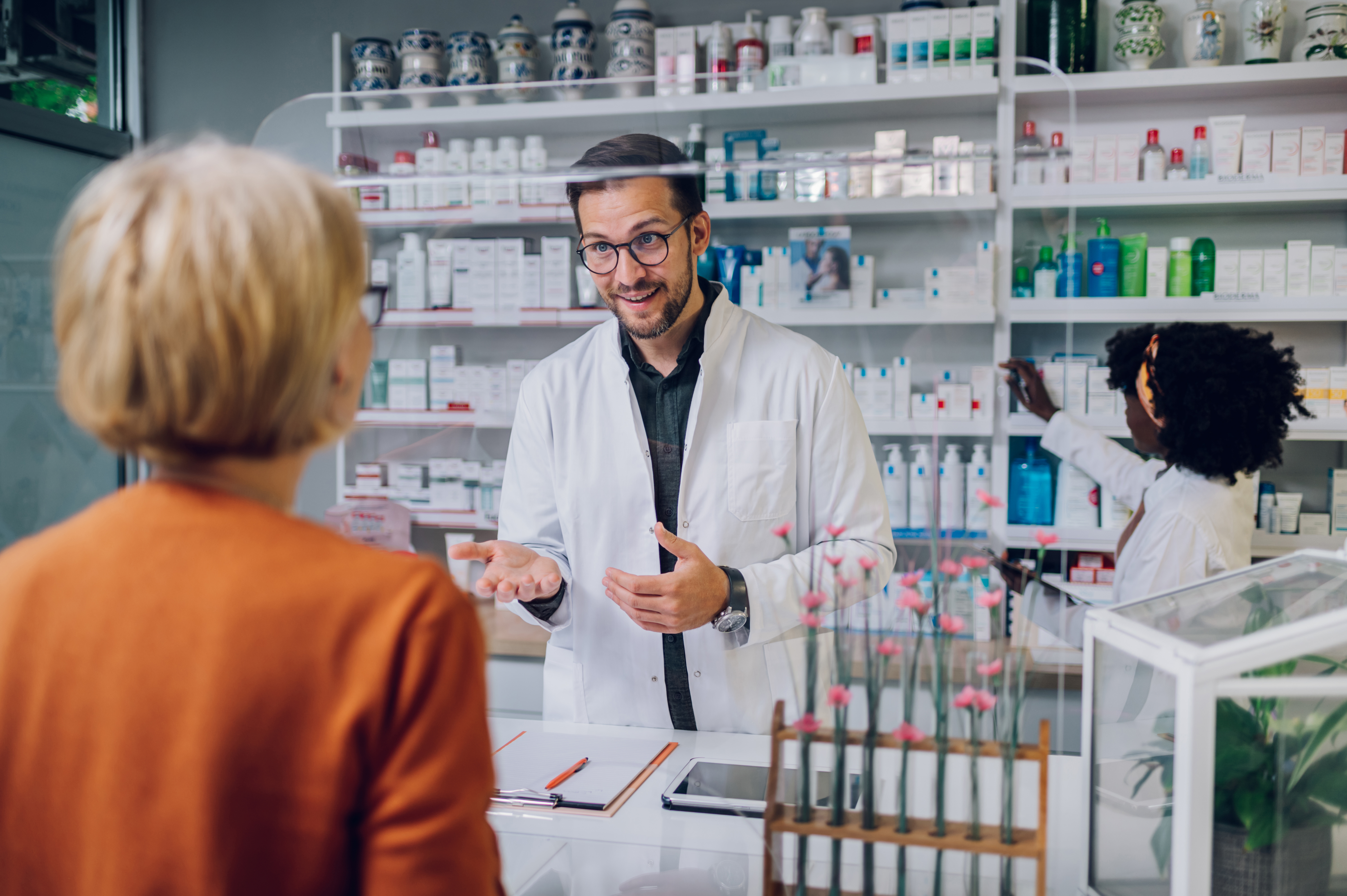 Portrait of a male pharmacist working at the counter in pharmacy